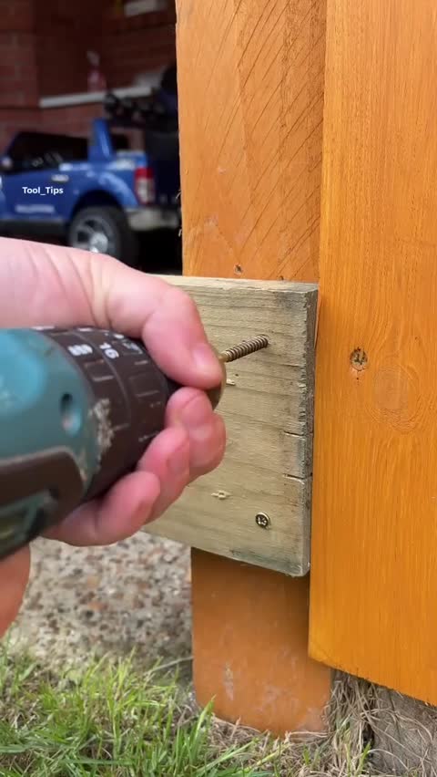 Electric Drill Driving a Screw into a Wood Plank